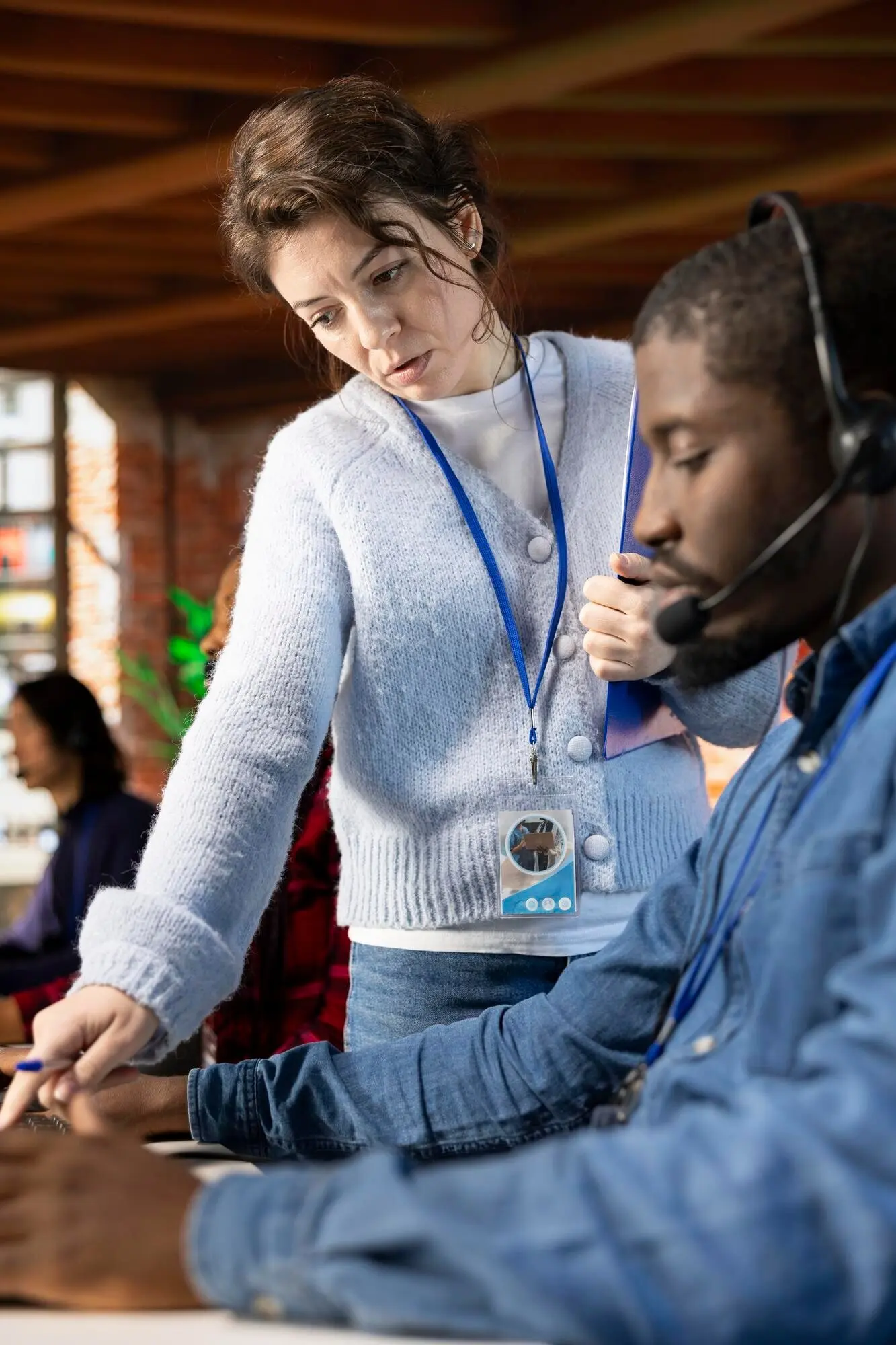 Nahaufnahme eines Callcenter-Managers, der einen Praktikanten anleitet.